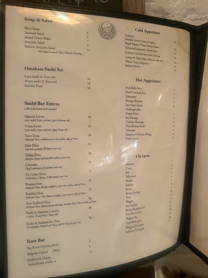 Sushi and ramen served in a dark dining room.